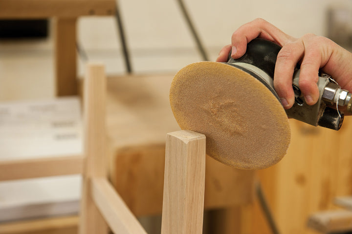 Amish craftsman sanding dining chair legs